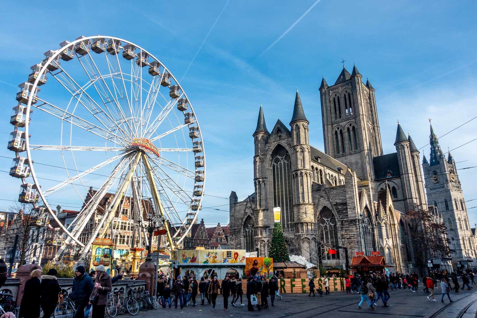 Ferris wheel and booths in front of St Nicholas Church in Ghent