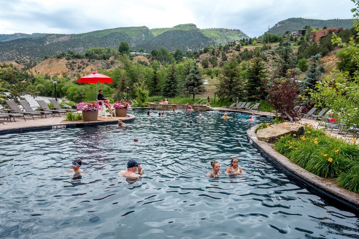 People swimming in a hot springs pool in the mountains.