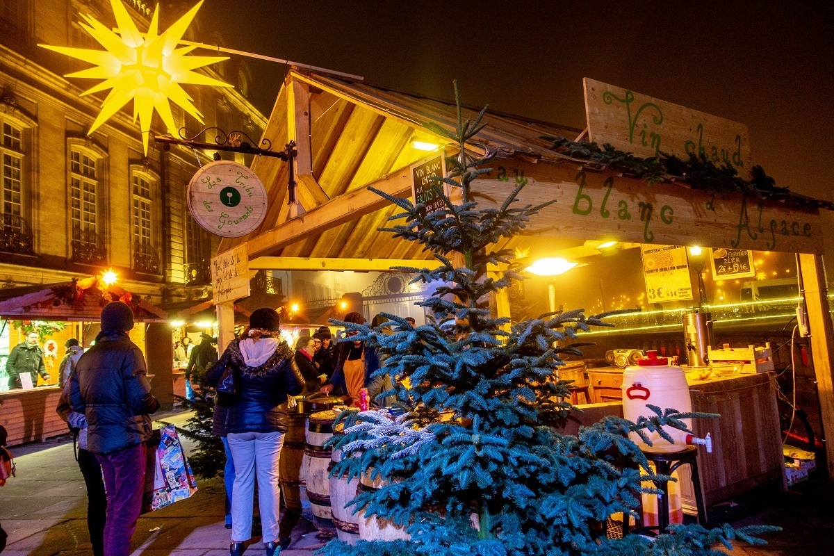 Chalet lit up at night selling Alsatian mulled wine in Palais Rohan in Strasbourg, one of the best Xmas markets in Europe