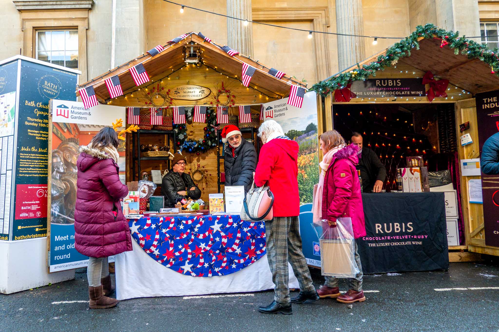 People at wooden chalet decorated with American flags in Bath, England