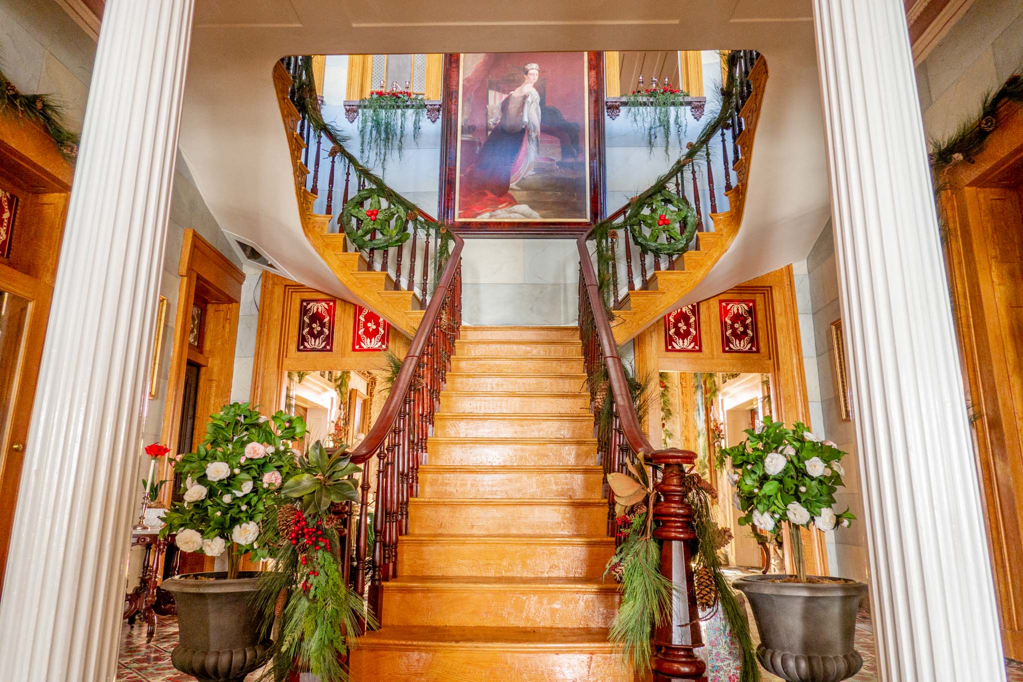 Large wooden staircase with a portrait at the top