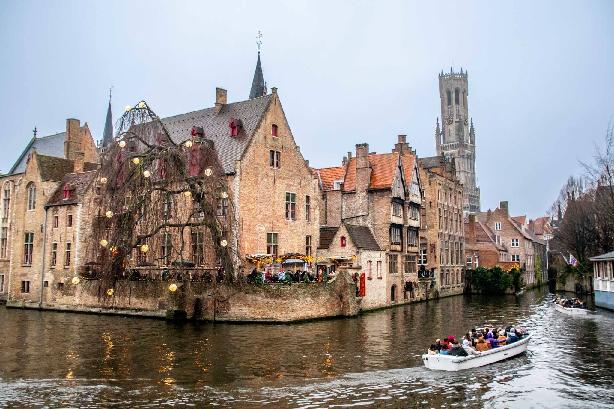 Two boats full of passengers in a canal in Bruges, Belgium