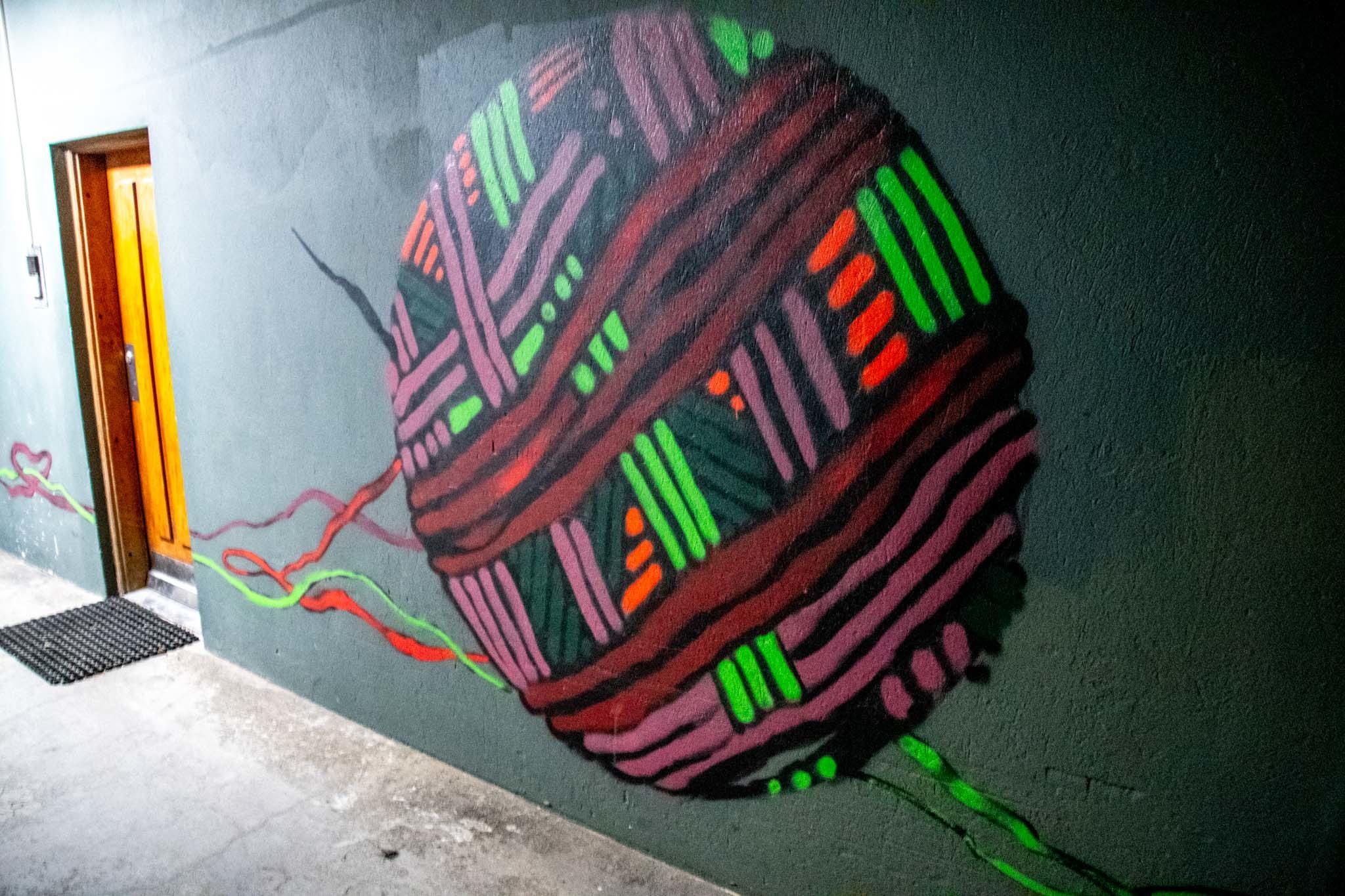 The ball of string is part of a two-part opposing mural.