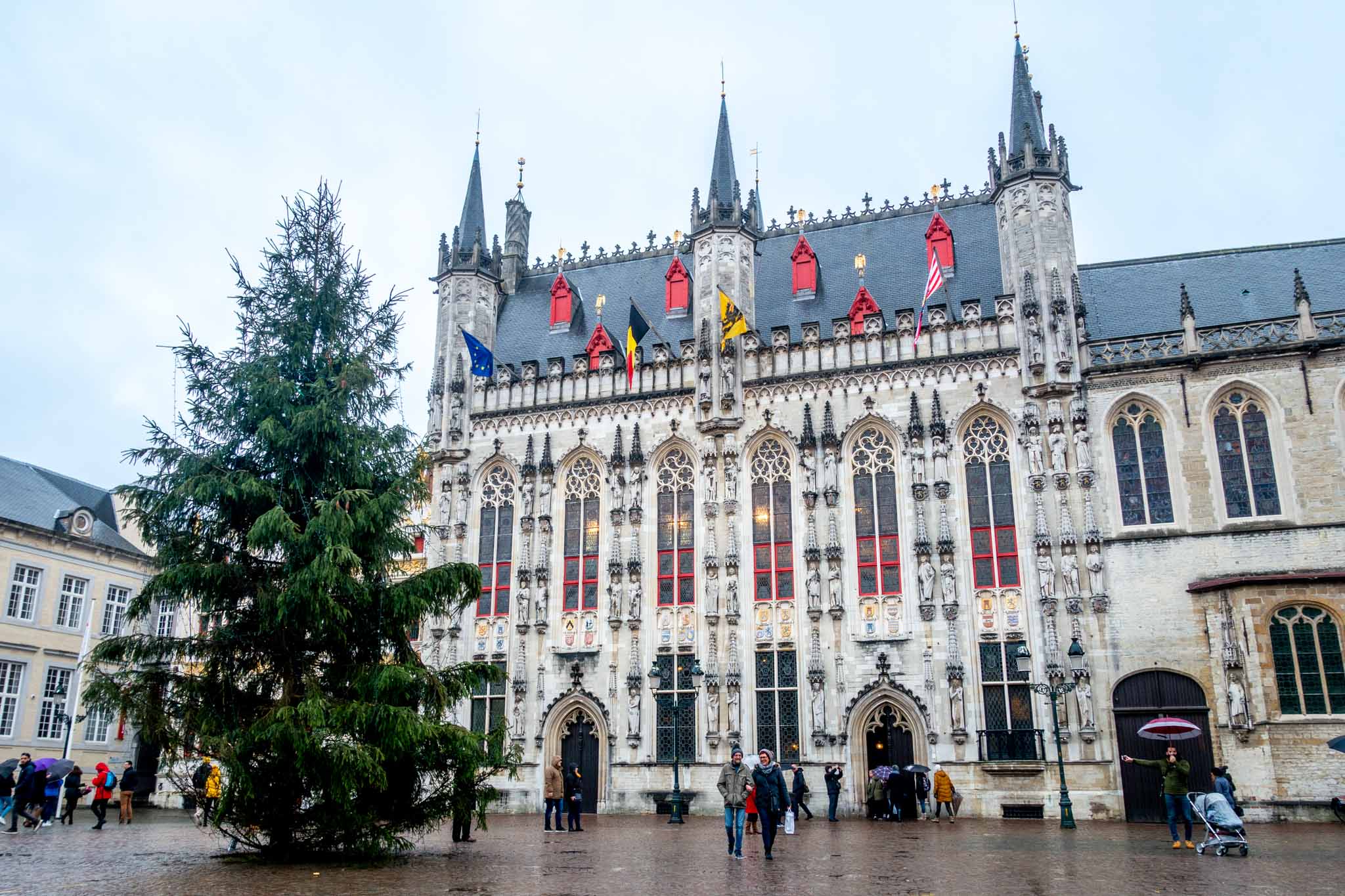 Christmas tree in front of a white building with red accents, the Town Hall