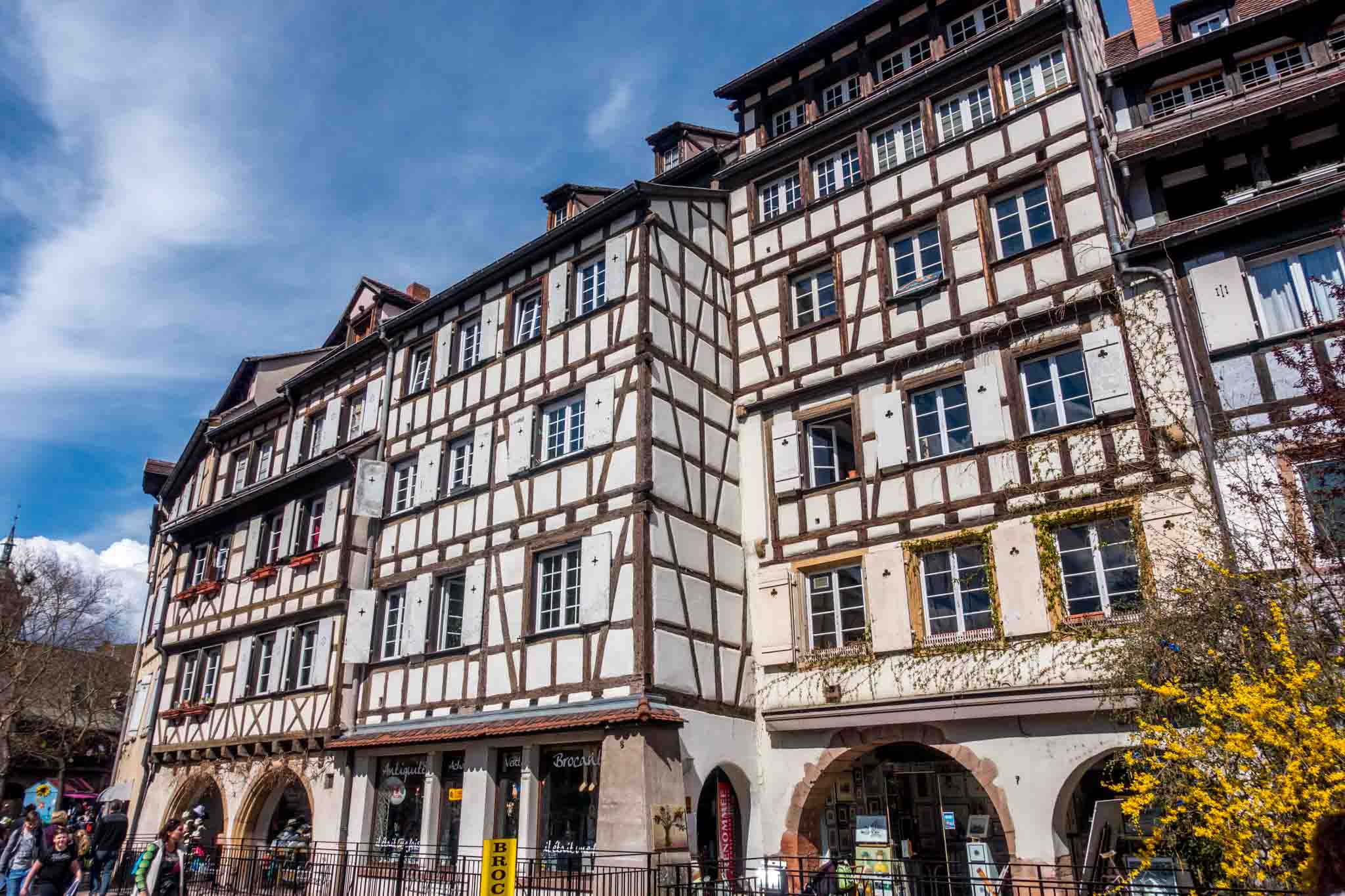 Row of white half-timbered buildings with stores on the first level