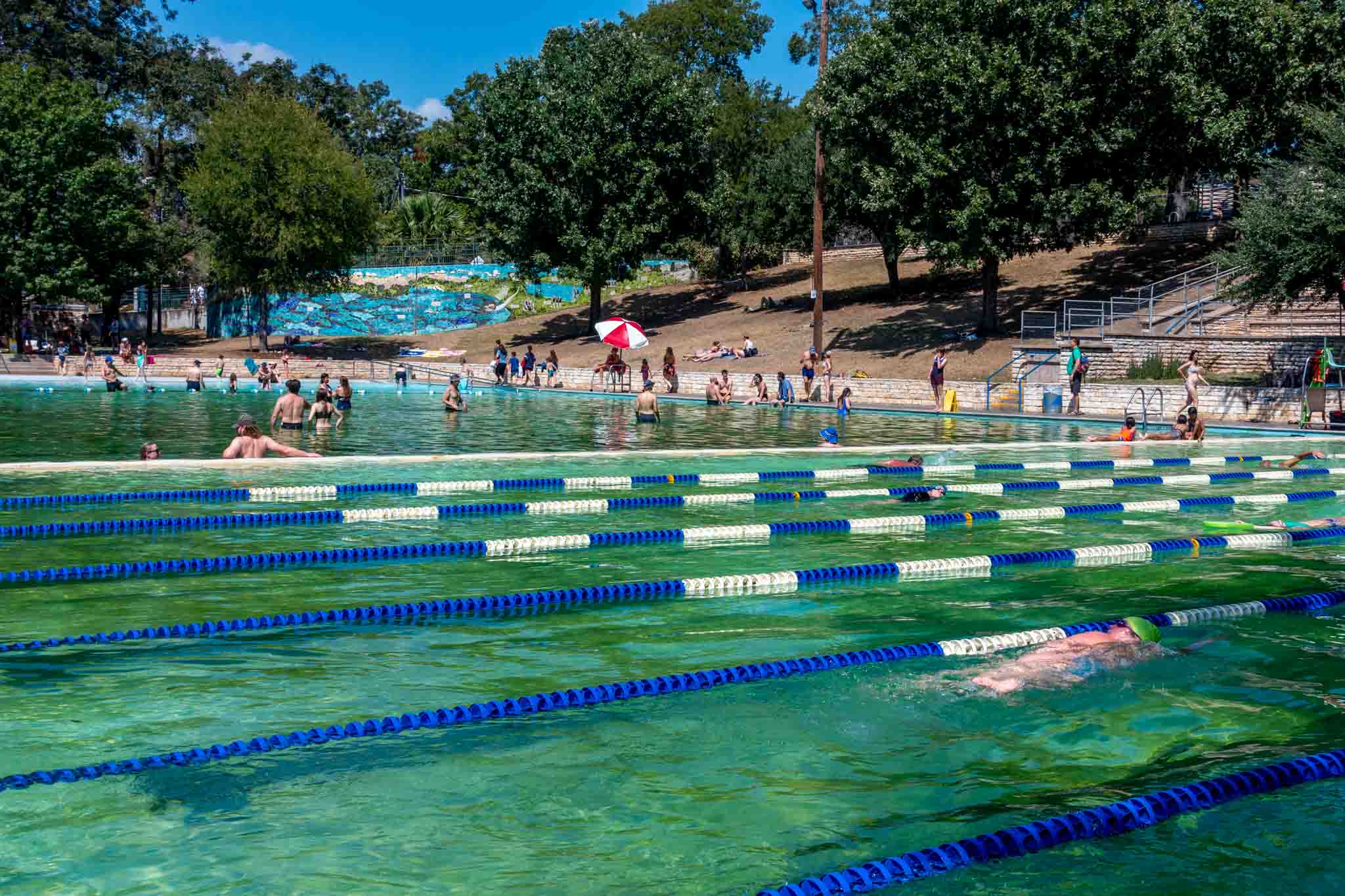 People at a large swimming pool, Deep Eddy Pool in Austin