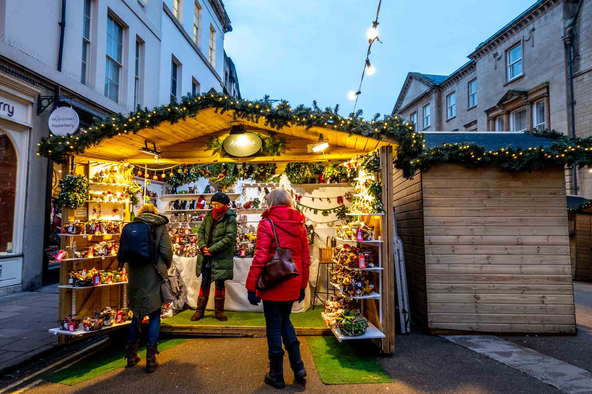 Shoppers at a wooden stall shopping for Christmas gifts