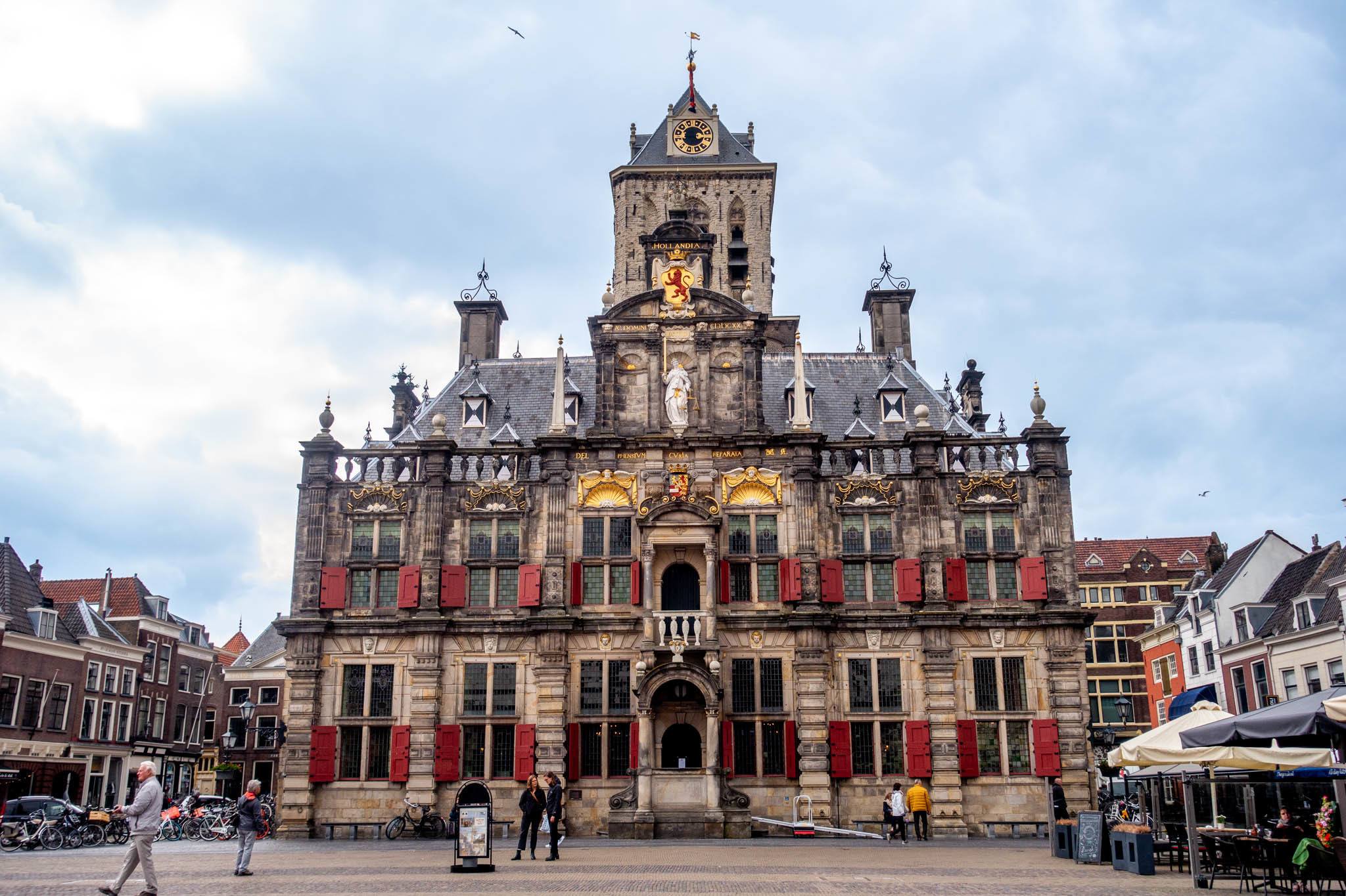 Town hall building with red shutters and gold decorations