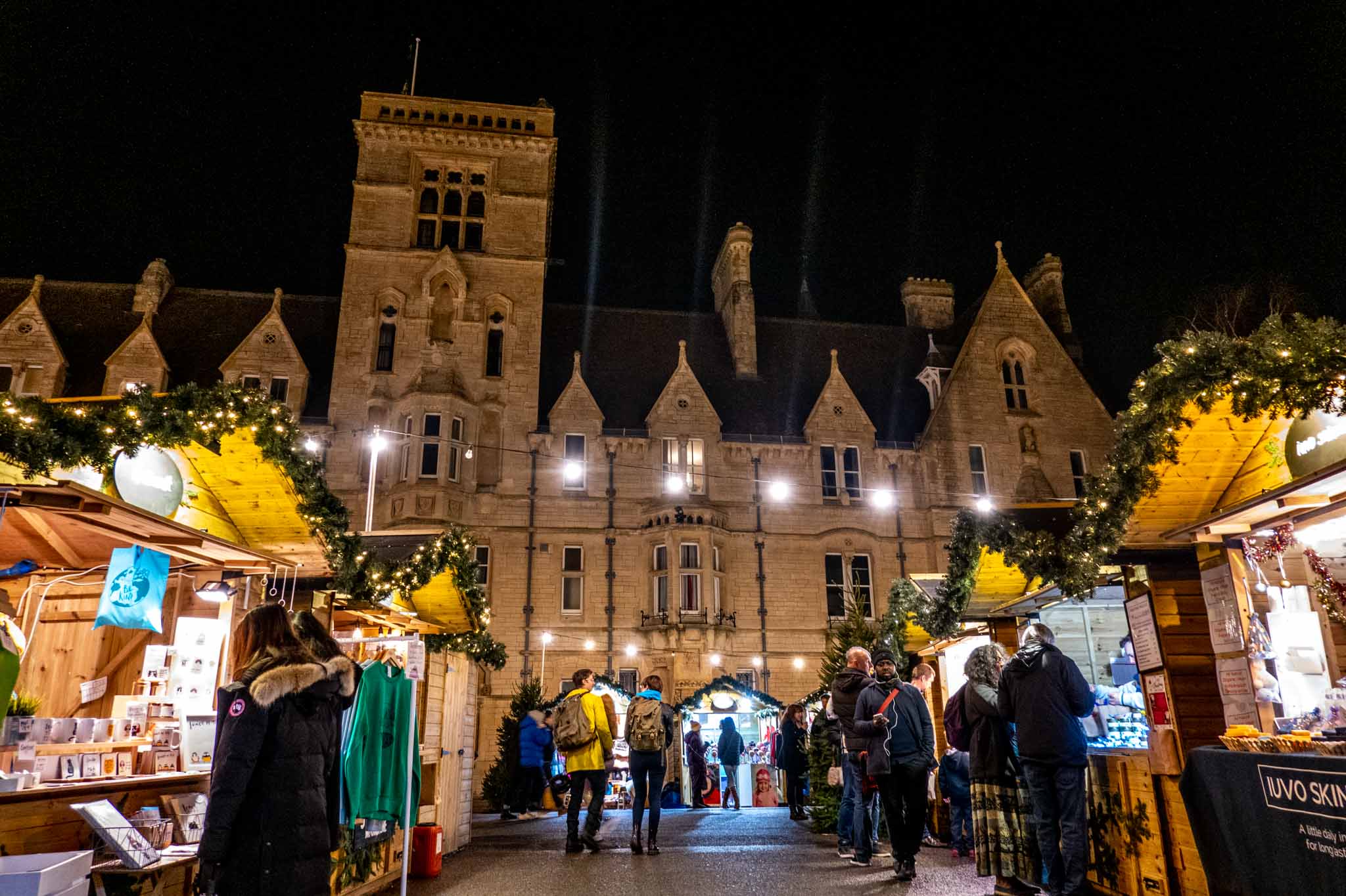 People shopping at the Oxford Christmas market with Balliol College buildings